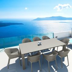 an outdoor table and chairs overlooking the ocean