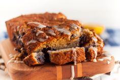 a loaf of blueberry bread sitting on top of a wooden cutting board