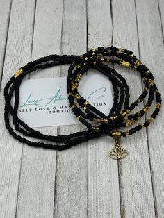 🌼🖤 Elevate your self-love and manifestation journey with our Black & Gold Waist Beads featuring a delicate Lotus Charm! 🖤🌼 ✨ Handcrafted with care and attention to detail, these exquisite waist beads combine the timeless elegance of black and gold. The lotus charm adds a touch of spiritual symbolism, representing growth, purity, and transformation. This waist chain is a perfect gift for her or a special treat for yourself. ⚡️ Designed to stretch comfortably and featuring a secure clasp, thes Adjustable Hand-strung Spiritual Waist Beads, Adjustable Spiritual Waist Beads, Handmade Adjustable Waist Beads For Gift, Adjustable Spiritual Waist Beads For Festival, Adjustable Holistic Jewelry For Yoga, Adjustable Black Beads Jewelry For Meditation, Adjustable Wrap Bracelet With 108 Beads For Meditation, Spiritual Jewelry With Tiny Beads For Meditation, Gold Waist Beads