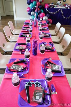 the table is set with purple and pink decorations