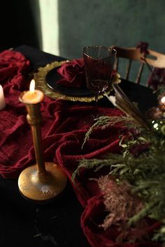 two candles are lit on a table with red cloths and other decorations around it