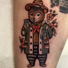 a tattoo with a bear wearing a hat and holding a beer in it's hand