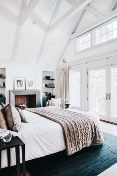 a bedroom with a large bed and fireplace in it