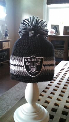 a knitted oakland football hat sitting on top of a table