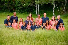 a large family poses for a photo in the tall grass with their two children and one adult