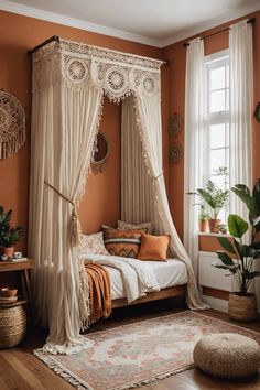 a canopy bed in a bedroom with orange walls and white curtains on the windowsill