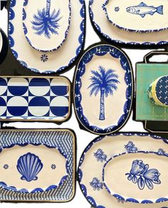 a collection of blue and white plates with palm trees on them, along with other dishes