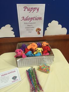 a box filled with lots of colorful candies next to a sign that says puppy adoption