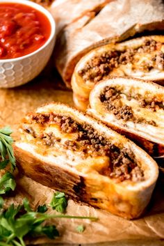 some bread with meat and sauce on a cutting board