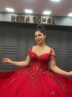 a woman in a red ball gown posing for the camera