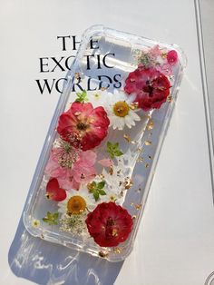 an iphone case with flowers on it and the words exotic world written in gold lettering