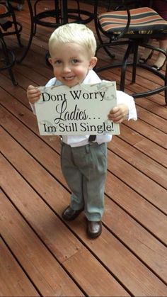 a little boy holding a sign that says don't worry cakes, i'm still single