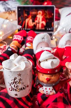 someone is holding a coffee cup with marshmallows in the shape of snowmen