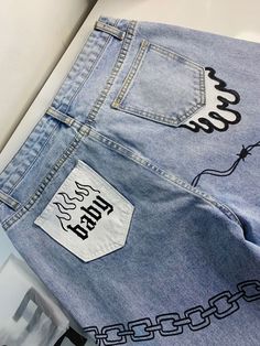 a pair of jeans with chains on them and some stickers on the back pocket