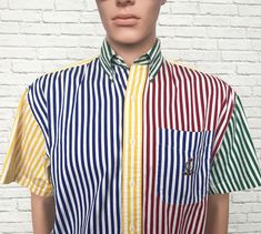 "✿ Mens 80s Chaps Ralph Lauren cotton short sleeve shirt. Features a rare yellow, red blue and green striped design throughout. Point collar with short sleeves, button down front and Chaps laurel wreath on the left chest patch pocket. Ultra soft and crisp cotton fabric. Rounded hemline. We love the sleeves rolled up or worn down. Looks great tucked in or out! Excellent vintage condition. Great find! ✿ Labelled size: Small Fits like: Mens Small to smaller medium depending on desired fit. ✂ Measur Retro Short Sleeve Shirt With Vertical Stripes, Retro Vertical Stripes Short Sleeve Shirt, Multicolor Short Sleeve Shirt With Vertical Stripes, Retro Striped Short Sleeve Shirt, Multicolor Vertical Stripes Shirt For Summer, Multicolor Vertical Stripes Summer Shirt, Multicolor Vertical Striped Summer Shirt, Retro Summer Shirt With Vertical Stripes, Retro Multicolor Short Sleeve Shirt