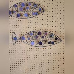 two metal fish on a pegboard with polka dot dots and blue circles in the middle