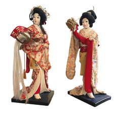 Enhance your collection with this exquisite pair of vintage Japanese Geisha dolls, each standing elegantly on a black lacquered wooden base. Dressed in richly detailed kimonos with intricate floral patterns and adorned with traditional geisha hairstyles, these theatrical figures capture the grace and beauty of Japanese culture. One figure holds a ceremonial hat with cascading white tassels, while the other presents a lion mask (shishigashira) with a flowing red scarf, showcasing their theatrical poses and cultural significance. Perfect for collectors and enthusiasts, these figures are a unique and valuable addition to any collection. Both dolls are in overall good vintage condition with wear, discolorations, possible minor losses, repairs and other marks and signs of the age and handling 1 Theatrical Poses, Geisha Hairstyles, Traditional Geisha, Geisha Doll, Lion Mask, Japanese Geisha, White Tassel, Kny Oc, Red Scarf