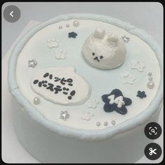 a white cake with black and white decorations on it's side, including a teddy bear