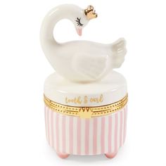 a white swan sitting on top of a pink and white container