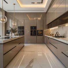 a modern kitchen with marble counter tops and stainless steel appliances, along with pendant lights