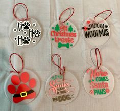 six christmas ornament ornaments on a white tablecloth with red and green lettering