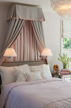 a bedroom with pink curtains and white bedding