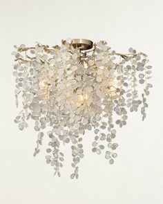 a chandelier with white and clear glass beads hanging from it's ceiling