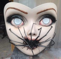 a creepy mask with blue eyes and spider webs on it's face is shown