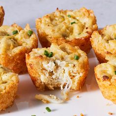 there are several small muffins with cheese and green onions in them on the plate