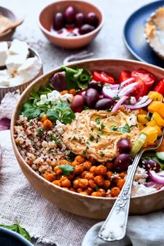 a wooden bowl filled with lots of different types of food and garnishes