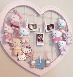 a heart shaped display with hello kitty stuffed animals and pictures hanging from it's sides