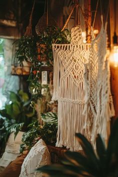 macrame hanging from the ceiling in a room filled with potted plants and greenery