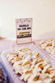 there are many sandwiches on the table and one has a sign that says wheels on the bus