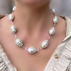 This stunning necklace is a must-have for anyone who loves the beauty and elegance of classic baroque jewellery. Crafted from solid mother of pearl, this piece boasts large, oval shaped mother of pearls measuring 17 x 21mm that are sure to make a statement wherever you go.  The necklace is strung with sterling silver S shaped tubes, which add a touch of modernity to the overall design. At the back, you'll find a large sterling silver 15mm bolt ring clasp, which not only secures the necklace but also adds a touch of sophistication to the design. Whether you're dressing up for a special occasion or simply looking to elevate your everyday style, this necklace is the perfect accessory to add a touch of glamour and elegance to any outfit. So if you're looking for a high-quality, beautifully cra Oval White Mother Of Pearl Necklace, Elegant Baroque Pearl Necklace In Pearl White, Luxury Silver Baroque Pearl Necklace, Luxury Baroque Pearl White Pearl Necklace, Pearl White Mother Of Pearl Shell-shaped Necklace, Pearl Baroque, Baroque Jewelry, Bolt Ring, Pearl Jewelry Design