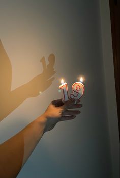 someone is holding out their birthday cake with candles in the shape of the number 19