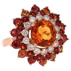 Sapphire Citrine Diamond Rose Gold Cocktail Ring A Stunning and Unique piece to say the least! We have named this piece MARIGOLD!! Our in-house designer is carefully curated this ring to make it look like the most beautiful flower! This Ring has a bold Round Cut Citrine Quartz that is blazing Orange! It weighs 5.14 Carats and is surrounded by a beautiful row of 14 Round Cut Diamonds that weigh 0.57 Carats (Clarity: SI2, Color: F). The ring is also accented with 14 Garnets that weigh 1.22 Carats Orange Gemstones, Rose Gold Cocktail, Colored Sapphires, Diamond Collection, Gold Cocktail Ring, Cluster Rings, Gold Cocktail, Most Beautiful Flowers, Orange Sapphire