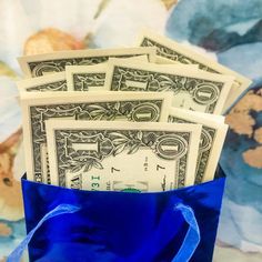 a blue bag filled with money sitting on top of a table