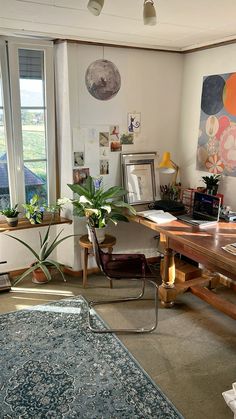 a living room filled with furniture and a large window next to a painting on the wall