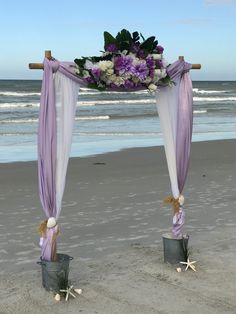 purple and white flowers are placed on the beach