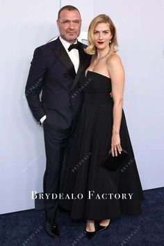 a man and woman standing next to each other on a blue carpet at an event