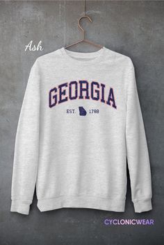 Vintage Style Georgia Unisex Crewneck Sweatshirt Perfect for any situation, these heavy blend crewneck sweatshirts are pure comfort. Made from a polyester and cotton combination which helps designs come out looking fresh and beautiful. The collar is ribbed knit, so it retains its shape even after washing. There are no itchy side seams on these sweaters. SIZING: Sweatshirts are unisex regular fit. Pick your usual size for a normal fit or size up for a more relaxed feel. Please check size chart for exact dimensions. PRODUCT DETAILS: -DTG printed using water based eco-friendly inks for a very soft feel that won't peel off or fade after washing. NO VINYLS OR PLASTIC STICKERS USED. -GILDAN Heavy Blend™ Sweatshirt -Medium-heavy fabric (8.0 oz/yd² (271 g/m²) -50% pre-shrunk cotton, 50% polyester Collegiate Crew Sweatshirt Pre-shrunk, Collegiate Crew Sweatshirt, Pre-shrunk, College Team Spirit Sweatshirt In Athletic Heather, Fleece Crew Sweatshirt For College, Crew Neck Fleece Sweatshirt For College, Athletic Heather Crew Neck Sweatshirt For Fan Gear, Athletic Heather College Sweatshirt For Team Spirit, Crew Neck Hoodie In Athletic Heather For College, Athletic Heather Crew Neck Hoodie For College