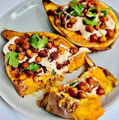 three baked sweet potatoes with chickpeas and cheese on a white plate, ready to be eaten