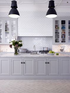 a kitchen with white cabinets and black lights