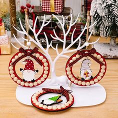 a christmas tree with two ornaments on it and a small wreath in front of it