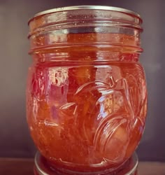 a jar filled with liquid sitting on top of a wooden table