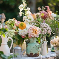 a table topped with lots of different types of flowers and vases next to each other