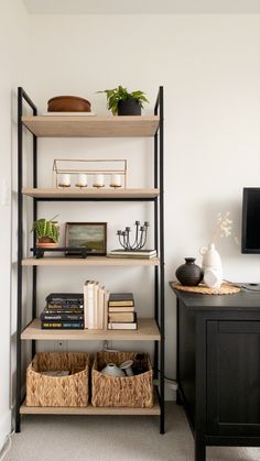 a book shelf with baskets and books on it