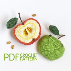 two crocheted apples sitting next to each other on top of a white surface