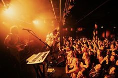 a group of people that are standing in front of a microphone and keyboard on stage