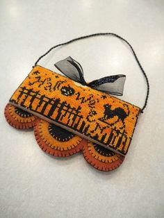 an orange and black beaded necklace with a bow